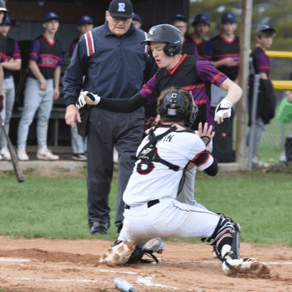 GMLOK runner Caden Reiter is tagged out at home plate by Spring Grove catcher Ezra Griffin during the first inning of the teams’ SEC contest. Reiter was injured on the play and did not return in a game where the Bulldogs led 1-0 and had the Lions down to their final out, only for SG to win 8-2 in eight innings. Photo by Lee Epps