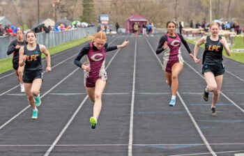 Chatfield’s Jaelyn LaPlante (second from left) crosses the finish line first while competing against teammate Savannah Peterson and LFC’s Charlotte Ferrie (left) and Kinley Soiney (right). LFCMC’s girls won the four-team track and field meet in Chatfield. Photo by Leif Erickson