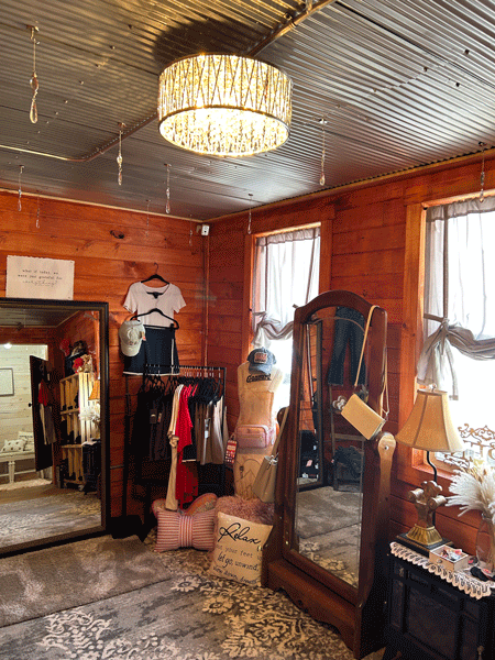 The boutique decor features galvanized ceilings, repurposed furniture, and crystal chandeliers and lights.
