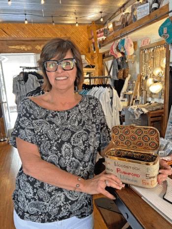 Owner Amy Engelhart displays a hand-needlecrafted purse that she purchased at an antique store in La Crosse long before she decided to open Boutique Station. Coincidentally, the original owner of the purse lived just down the block from where Amy now lives on Steven’s Avenue in Rushford. Amy enjoys decorating the boutique with antique items.