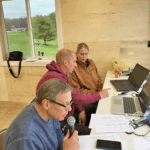 Seen in the new press box are Randy Paulson, announcer and Jeff Debuhr, head track coach explaining the duties of timing to Sarah Thieke. Photo by Mary Allen