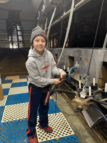 Eli helps his dad change milker inflations. Photo submitted