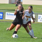 Siri Konkel (left) of Caledonia/Spring Grove/Houston contends for possession with Stewartville’s Jesica Eden. The Warrior midfielder/forward scored once and assisted on two other goals as the Warriors blanked the Tigers, 3-0. Photo by Lee Epps