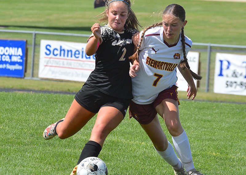 Siri Konkel (left) of Caledonia/Spring Grove/Houston contends for possession with Stewartville’s Jesica Eden. The Warrior midfielder/forward scored once and assisted on two other goals as the Warriors blanked the Tigers, 3-0. Photo by Lee Epps