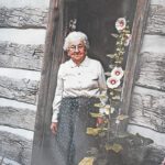 Ragnhild St. Mary stands in the doorway of the 1880 Pioneer Log Cabin, where she demonstrated spinning wool for more than three decades at the Houston County Fair. Photo courtesy of the Houston County Historical Society