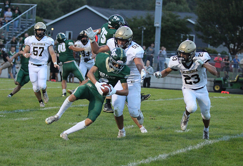 A pivotal play in the game, Caledonia’s Cooper Allen (#52) and Jack Schmitz (#23) tackle Rushford-Peterson’s Will LaFleur near the goal line following an interception. LaFleur fumbled, but R-P’s Jaxson Meldahl recovered for a touchdown, part of the Trojans’ notable 21-14 season-opening win. Photo by Paul Trende