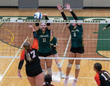 Rushford-Peterson’s Madison Ingvalson and Ava Helgemoe form a double-block on the attack of St. Charles’ Kierstyn Sanders in the Trojans’ 3-0 homecoming sweep. R-P (4-1, 7-2) sits behind Caledonia (6-0, 15-3) and Fillmore Central (5-0, 13-4) in the TRC standings. Photo by Dawn Hauge