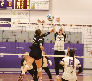 Grand Meadow’s Holly Weiss (near #11) and Kingsland’s Sydney Wendt (far #7) vie at the net for the ball in the teams’ SEC matchup, a 3-0 Lark sweep. Photo by Christine Vreeman