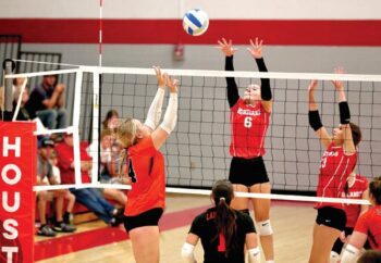 Houston’s Olivia Yohe goes high and teammate Lydia Pedretti is also there defensively to try to stop the two-hand push attack by Lanesboro’s Hailey Erickson. The ‘Canes posted maybe their best win of the year, beating the Burros in five sets, 3-2 (18-25, 25-22, 9-25, 25-23, 15-12). Photo by Craig Johnson