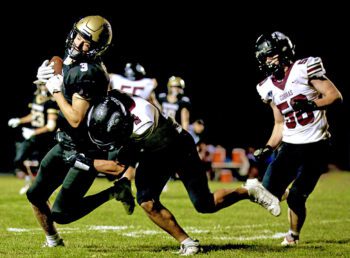 Caledonia’s Grant King gets tackled by Triton’s Graden Thomas in the teams’ key Southeast Central football affair. The Cobras, a state qualifier last year, got standout Pierce Petersohn back, and downed the Warriors 13-3. Photo by Craig Johnson