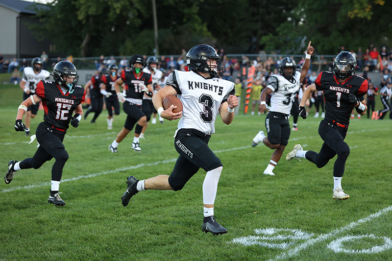 Kingsland’s KD Reiland (background) hopes for the best as teammate Bently Wiersma runs free in the Knights’ key matchup with Alden-Conger/Glenville-Emmons in week three. The game was called early per an injury to an AC/G-E player (which facilitated a medivac). The Knights moved to 3-0 with a 22-12 win. Photo by Christine Vreeman