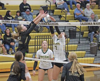 Caledonia’s Adrienne Lange (left) and Rushford-Peterson’s Shelby Tesch (right) battle at the net in the teams’ TRC season-opener. R-P (1-1, 2-1) attempted to steal a set twice, but fell to the Warriors (3-0, 4-0) by 3-0 sweep (25-8, 25-20, 25-20). Photo by Paul Trende