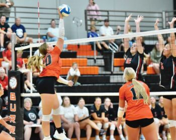 Lanesboro’s Jentrey Schreiber attacks into the double block of Spring Grove defenders Hailey Normann (#12) and Kylie Hammell. The Burros topped the Lions in five sets, ending an eight-match series losing streak. Photo by Ron Mayer