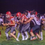 Houston’s Elliot Frauenkron battles forward against the Spring Grove defenders including Christian Bjerke (#34), Caden Gerard (#15), and others. Houston ended a 20-game losing streak to the Lions via a 24-18 victory. Photo by Emma Geiwitz