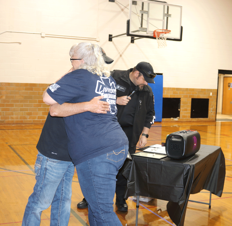 Caleb Hareldson gets a hug from EMR Darcy Peterson. Photo by Barb Jeffers