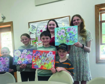 Sunday School students display flower pictures that they created to sell; proceeds were used to support an orphanage in Africa. Photo submitted