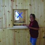 Preston Historical Society President Sheila Craig gave an impromptu tour of the Preston Depot Museum and Riverfront Center. She points out one of the future hands-on interpretive exhibits, a ticket booth. Photo by Charlene Corson Selbee