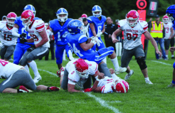 Mabel-Canton’s Kale Eiken tumbles over Houston’s Axel Vix in the teams’ South-East sub-district match-up. The Cougars jumped out 20-0, held off a Hurricane push, ultimately prevailing 32-14 to improve to 2-0. Photo by Paul Trende