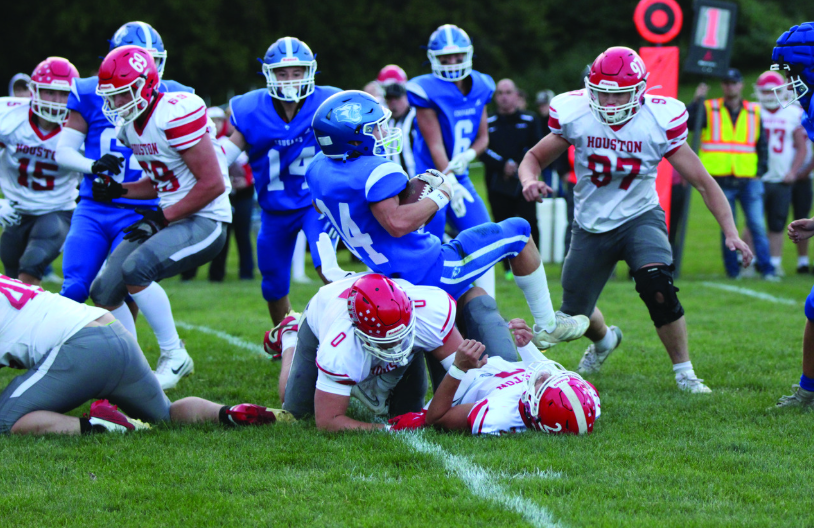 Mabel-Canton’s Kale Eiken tumbles over Houston’s Axel Vix in the teams’ South-East sub-district match-up. The Cougars jumped out 20-0, held off a Hurricane push, ultimately prevailing 32-14 to improve to 2-0. Photo by Paul Trende