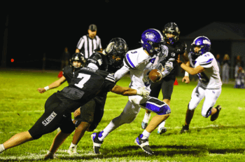 Kingsland’s KD Reiland (trailing play) knocks the ball away from Grand Meadow’s Blake Hubbard, while Knight Michael Johnson is also pictured. In a game with several turnovers, the 2-0 Knights pitched their second straight shutout in a 36-0 win. Photo by Christine Vreeman