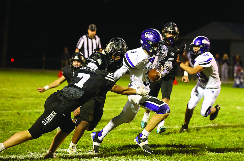 Kingsland’s KD Reiland (trailing play) knocks the ball away from Grand Meadow’s Blake Hubbard, while Knight Michael Johnson is also pictured. In a game with several turnovers, the 2-0 Knights pitched their second straight shutout in a 36-0 win. Photo by Christine Vreeman