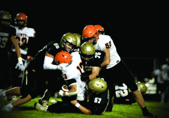 Caledonia defenders Cooper Allen (#52), Anthony VonArx (#75), and Charlie Mauss (#57) combine to take down St. Charles’ Bryndon Koeppel. The Warriors rallied from a tough week one loss by taking it to the Saints 40-18 in week two. Photo by Craig Johnson