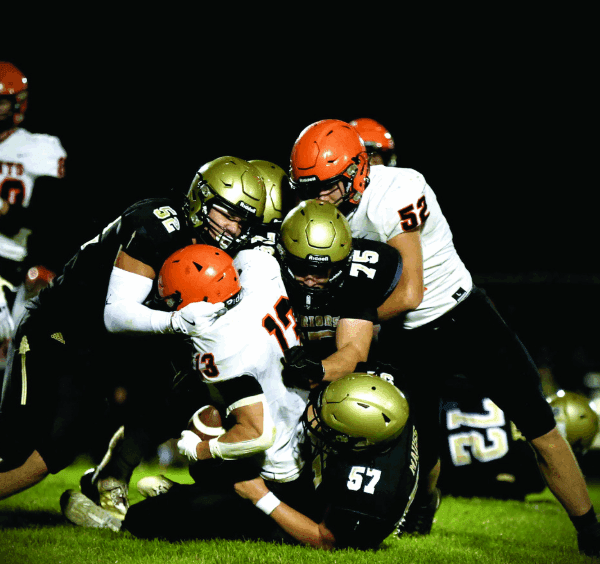 Caledonia defenders Cooper Allen (#52), Anthony VonArx (#75), and Charlie Mauss (#57) combine to take down St. Charles’ Bryndon Koeppel. The Warriors rallied from a tough week one loss by taking it to the Saints 40-18 in week two. Photo by Craig Johnson