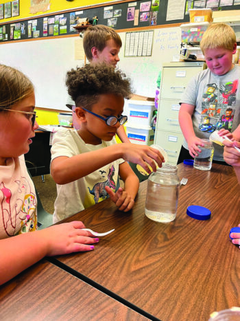 Students at St. Johns conduct an experiment together. Photo submitted