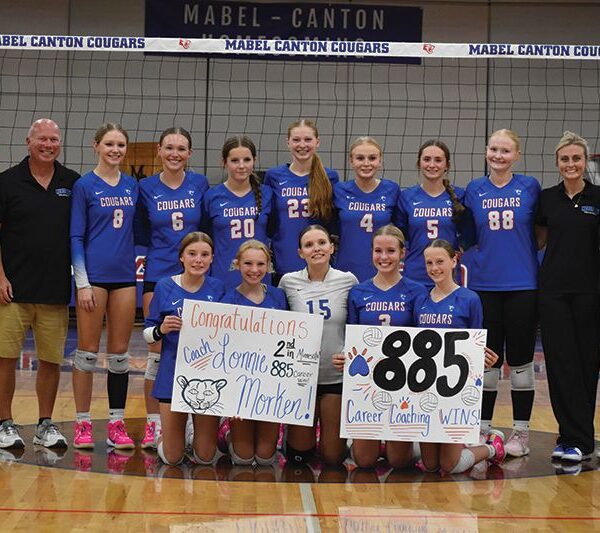 Mabel-Canton head volleyball coach Lonnie Morken (second from left in back row) poses with his team and assistant coaches after winning his 885th career match versus Kingsland. Doing so moved Morken into second place all-time in state history behind Stewartville former head John Dzubay (1,039). Photo by Heather Kleiboer