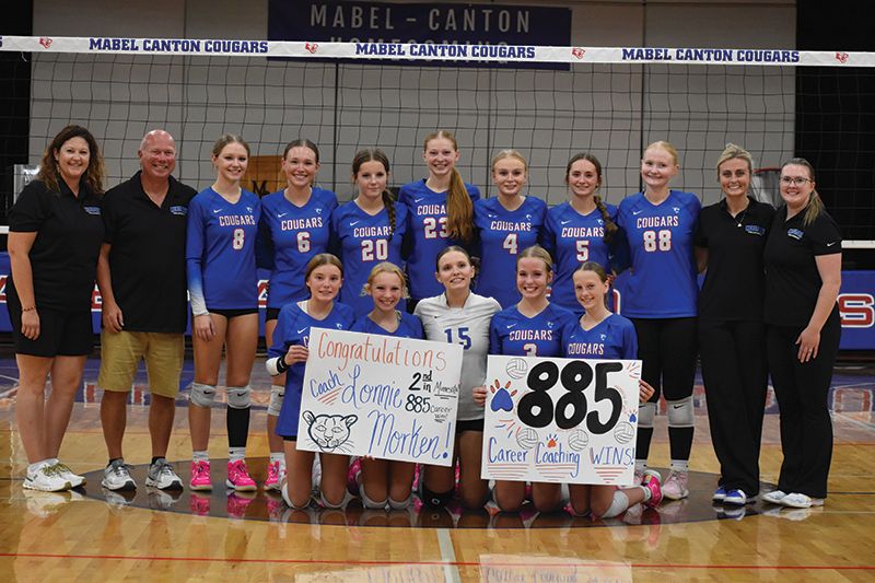 Mabel-Canton head volleyball coach Lonnie Morken (second from left in back row) poses with his team and assistant coaches after winning his 885th career match versus Kingsland. Doing so moved Morken into second place all-time in state history behind Stewartville former head John Dzubay (1,039). Photo by Heather Kleiboer