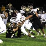 In a renewal of a bitter Class AA rivalry, Caledonia got redemption on a loss in last year’s 1AA title game by knocking #2 Chatfield from the ranks of the undefeated. Jack Schmitz (#23) and Cooper Allen (#52) curtail Gopher running back D’Andre Williams as a part of the Warriors’ 14-0 win. Photo by Paul Trende
