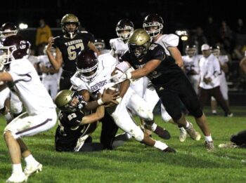 In a renewal of a bitter Class AA rivalry, Caledonia got redemption on a loss in last year’s 1AA title game by knocking #2 Chatfield from the ranks of the undefeated. Jack Schmitz (#23) and Cooper Allen (#52) curtail Gopher running back D’Andre Williams as a part of the Warriors’ 14-0 win. Photo by Paul Trende