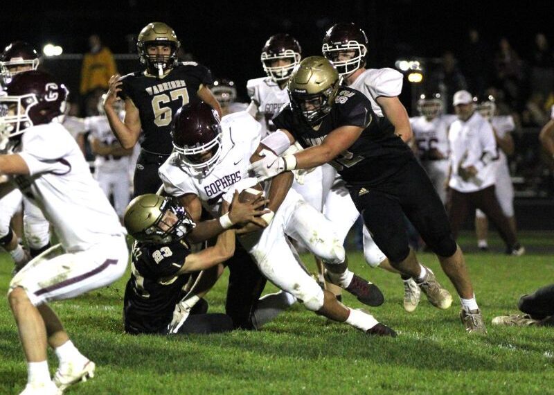 In a renewal of a bitter Class AA rivalry, Caledonia got redemption on a loss in last year’s 1AA title game by knocking #2 Chatfield from the ranks of the undefeated. Jack Schmitz (#23) and Cooper Allen (#52) curtail Gopher running back D’Andre Williams as a part of the Warriors’ 14-0 win. Photo by Paul Trende