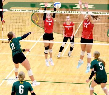 Rushford-Peterson’s Torryn Schneider attacks versus Houston defenders Olivia Yohe (#6) and Jorja Meyer (#14) in the Trojans’ 3-1 non-conference win. By week’s end, R-P was 18-4 overall, having started the year 16-4, best for the program in over a decade through 20 matches. Photo by Craig Johnson