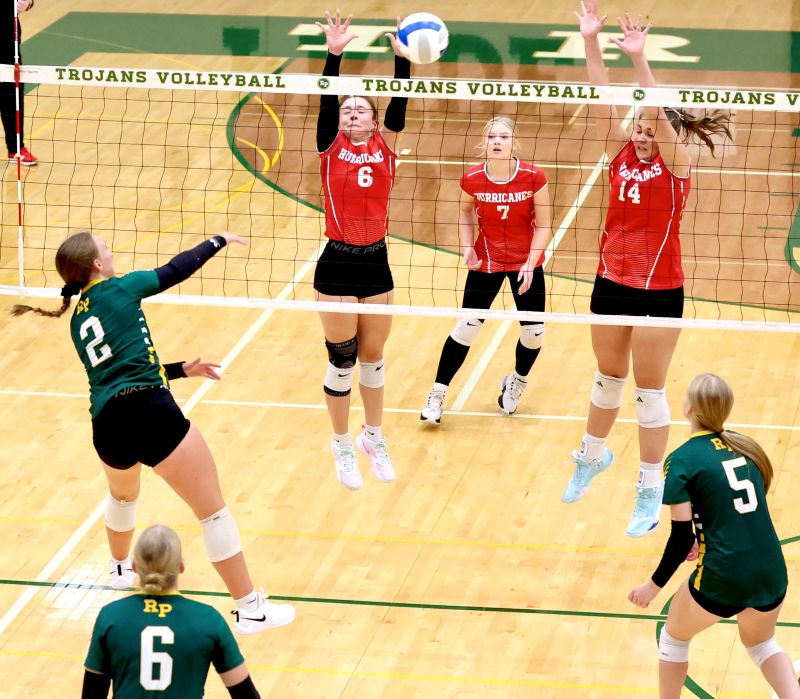 Rushford-Peterson’s Torryn Schneider attacks versus Houston defenders Olivia Yohe (#6) and Jorja Meyer (#14) in the Trojans’ 3-1 non-conference win. By week’s end, R-P was 18-4 overall, having started the year 16-4, best for the program in over a decade through 20 matches. Photo by Craig Johnson