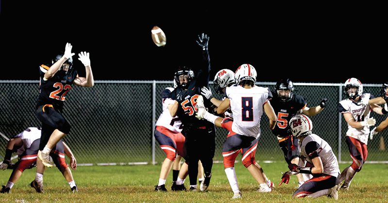 Lanesboro rushers Boone Moen (#22), Jackson Hearon (#56), and David Harvey (#5) get after the PAT attempt by Faribault B.A.’s Thomas Kunze. The Burros got four turnovers from the defense in a 33-27 win, Lanesboro’s first of the year. Photo by Craig Johnson