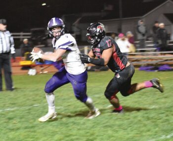 Spring Grove’s Noah Heppner will sack Grand Meadow quarterback Carter Glynn in the teams’ 9-Man playoff quarterfinal. SG beat the Larks 50-6. Photo by Lee Epps