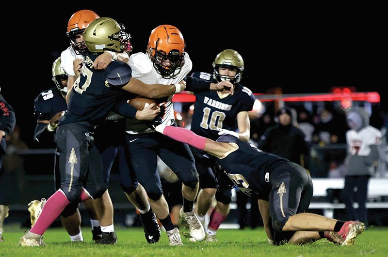 Caledonia’s Rae’Shaun Smith and Noah Schreoder combine to bring down a St. Charles ballcarrier in the teams’ 1AA quarterfinal. In dominating fashion, the Warriors topped the Saints 33-10 and then 2-seed Triton 39-7 to move on to the 1AA finals. Photo by Craig Johnson
