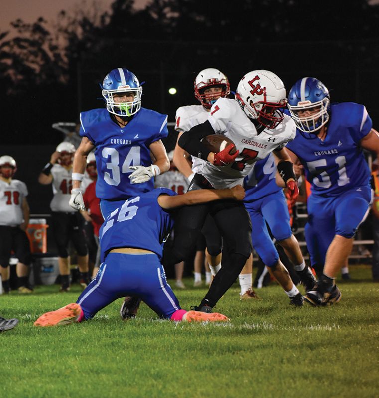 Mabel-Canton’s Hunter Kelly tackles LeRoy-Ostrander/Lyle/Pacelli’s Talan Lewison while Cougars Kale Eiken (#34) and Milton Hutchinson (#51) also lurk. M-C jumped out on the Cardinals 46-6 in the second quarter and prevailed 61-34. At 5-0, they lead the South-East sub-district. Photo by Heather Kleiboer