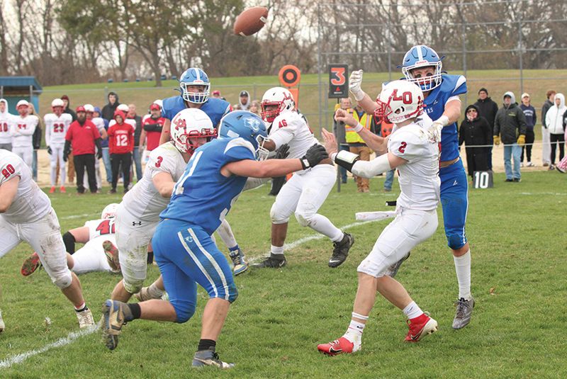 Mabel-Canton’s Breyvn Tollefsrud and Milton Hutchinson (#51) apply pressure to LeRoy-Ostrander/Lyle/Pacelli’s Reid Hungerholt in the teams’ 9-Man playoff semifinal. The Cougars moved to their first section title game since 2007 via a 29-20 win. Photo by Paul Trende