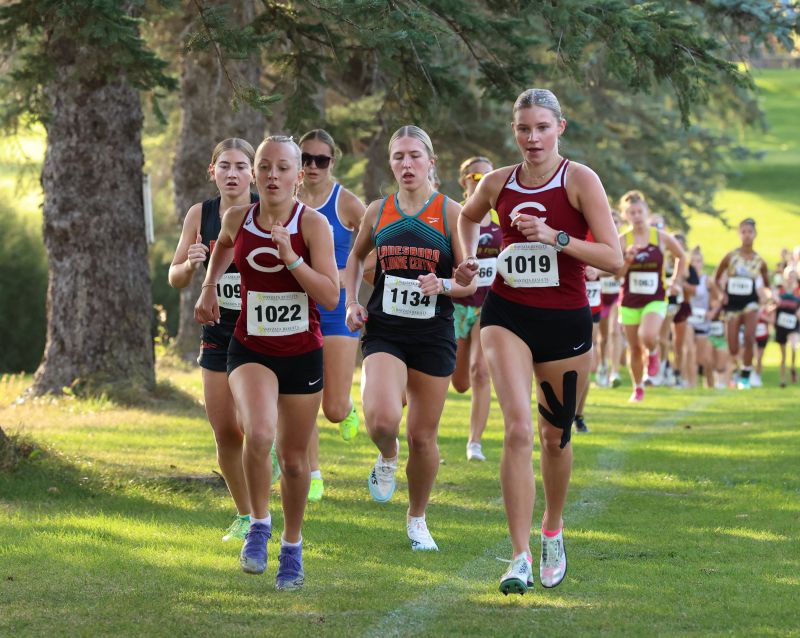 Five gals run in a pack early in the PEM Jodi Rahman cross country meet including prominently Chatfield’s Adeline Schild (left) and Lexi Kivimagi (right) plus LFC’s Lillyan Kiehne (middle) and LARPH’s Caitlin Bauer (mostly occluded left). All four finished top 10 at the event. Photo by Christine Vreeman