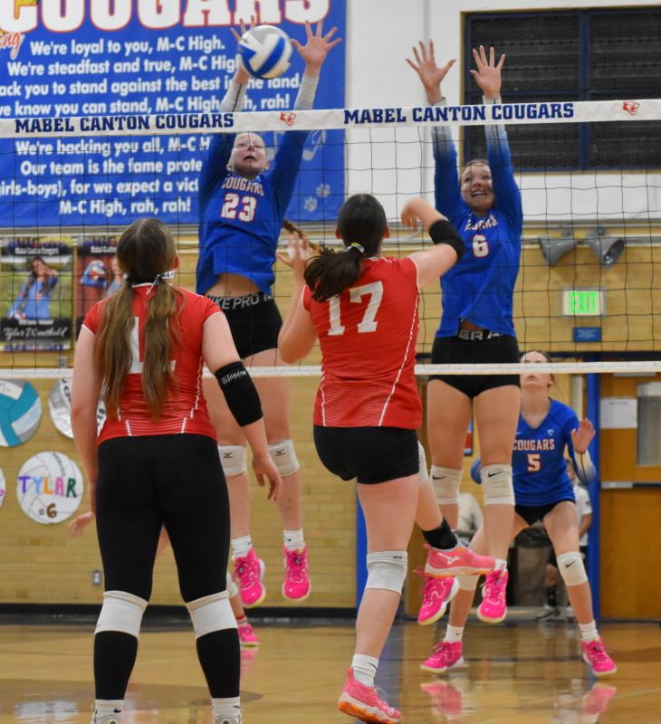 Mabel-Canton senior Kinley Soiney and Tylar Wenthold are there for the block on Houston’s Averie Evanson in the Cougars’ 3-0 sweep. Sixth-ranked M-C (11-0, 24-3) also swept Glenville-Emmons on the week to clinch at least a share of the SEC-East, their 28th straight league title. Photo by Heather Kleiboer