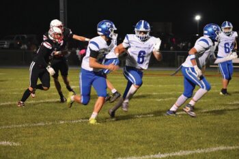 Mabel-Canton’s Breyvn Tollefsrud is in the open with a bit of a convoy from blockers Isaac Underbakke (left) and Darian Hershberger (right). The Cougars topped Wabasha-Kellogg 37-14 to clinch an 8-0 regular season. Photo by Heather Kleiboer: