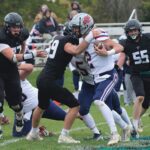 Fillmore Central defender William Boettcher has United South Central’s Kolt Bullerman in his grasp while Falcons Joseph Otto (#77) and Jeramiah Bushman (#55) look to help on the tackle. FC topped the Rebels 34-7 to move on to their fifth straight 1A title game. Photo by Paul Trende