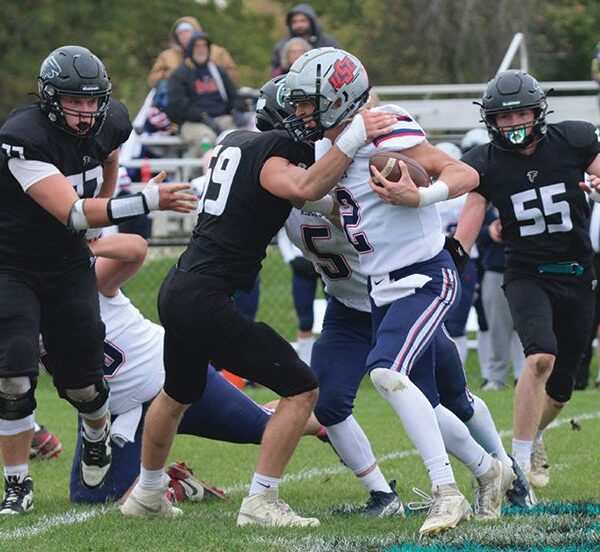 Fillmore Central defender William Boettcher has United South Central’s Kolt Bullerman in his grasp while Falcons Joseph Otto (#77) and Jeramiah Bushman (#55) look to help on the tackle. FC topped the Rebels 34-7 to move on to their fifth straight 1A title game. Photo by Paul Trende