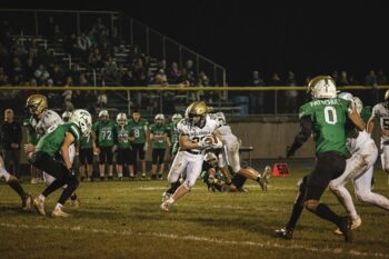 Caledonia’s Hunter Frank looks to elude a La Crescent/Hokah defender in the Warriors’ 40-7 win at the Lancers. Team Cal (6-2) won its fifth in a row. Photo by Isaac Blocker:
