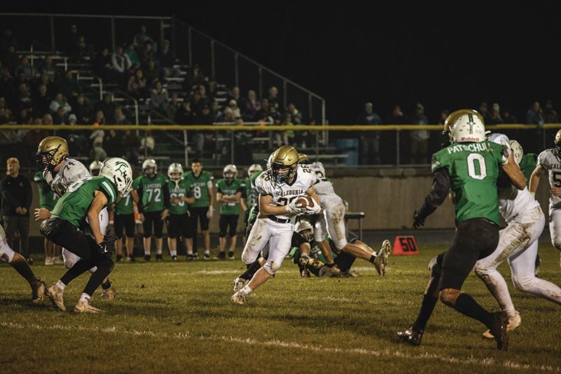 Caledonia’s Hunter Frank looks to elude a La Crescent/Hokah defender in the Warriors’ 40-7 win at the Lancers. Team Cal (6-2) won its fifth in a row. Photo by Isaac Blocker: