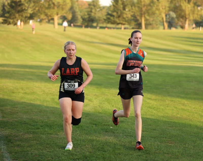 LARPH’s Vada Larson and LFC’s Charity Kingsley (right) compete amidst a cross country meet in Lewiston. Kingsley took 11th, helping the Burros to a second-place team finish, while Larson took 21st (of 62 total runners), leading her team. Photo by Christine Vreeman