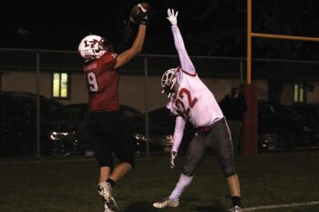 LeRoy-Ostrander/Lyle/Pacelli’s Hunter Wollenberg catches a touchdown pass over the outreaching arm of Houston’s Isaac Brand. Wollenberg caught two scores and the Cards took advantage of five turnovers in toppling an injury-beleaguered Houston squad 42-6. Photo Paul Trende