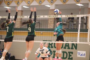 Fillmore Central’s Kyla Hellickson attacks versus the Rushford-Peterson block of Shelby Tesch (#7) and Ariana Bettinger (#9). The Falcons outlasted the Trojans in five sets and are Section 1A’s top seed in the playoffs. Photo by Paul Trende